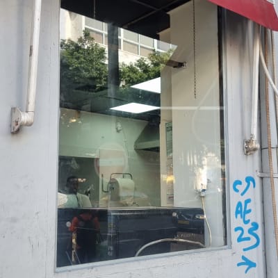 חלון זכוכית עם השתקפות אנשים וגרפיטי על הקיר