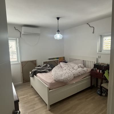 חדר שינה עם מיטה, מנורה ותמונות על הקיר