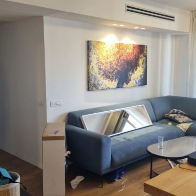 סלון עם ספה, ציור על הקיר ומראה על הספה