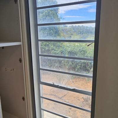 חלון אלומיניום עם נוף חיצוני ועץ ירוק