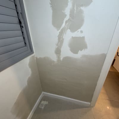 קיר מטויח עם תיקוני טיח ליד חלון