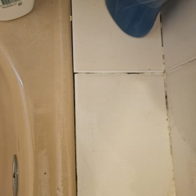 אריחים ליד כיור עם בקבוק חומר ניקוי