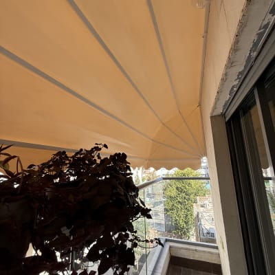 מרפסת עם סוכך כתום וצמחייה