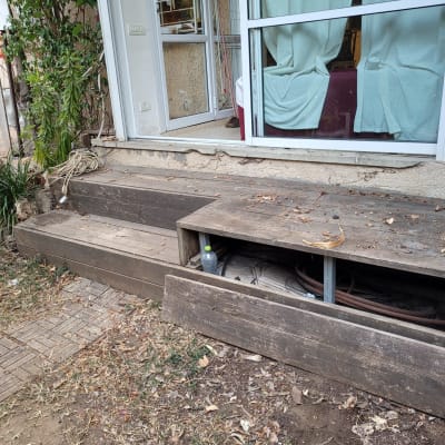 מדרגות עץ עם צינור גינה מתחת