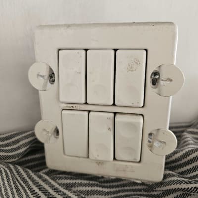 מתגי חשמל על קיר לבן עם ברגים