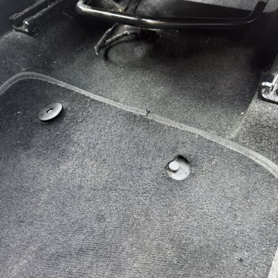 רצפת רכב עם שטיח כהה וחלקי מתכת חשופים