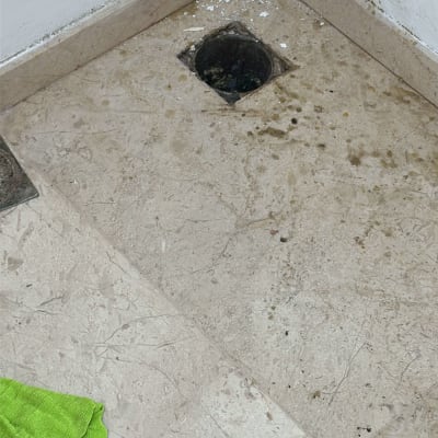 פתח ניקוז ברצפה עם לכלוך מסביב