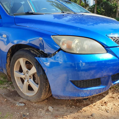 פגוש קדמי כחול פגום עם שריטות ועיקומים