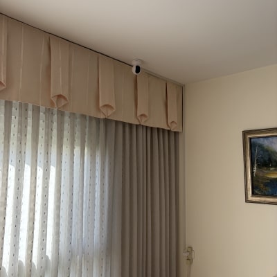 מצלמת אבטחה מותקנת בפינת חדר ליד וילון