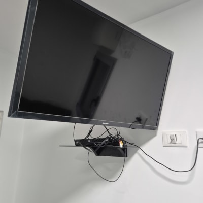 טלוויזיה מותקנת על קיר עם כבלים חשמליים