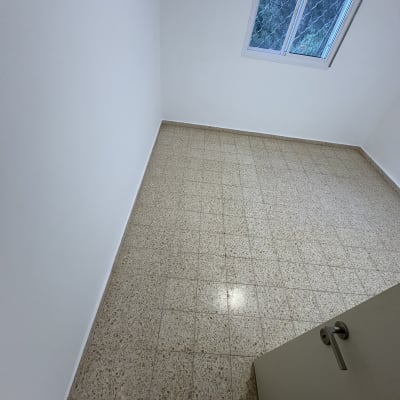 חדר ריק עם רצפת אריחים וחלון פתוח