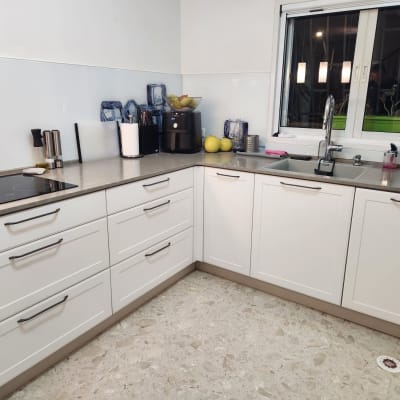 מטבח מודרני עם ארונות לבנים ומשטח עבודה אפור