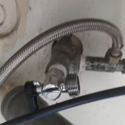 צינור מתכת מחובר לשסתום מתחת לכיור