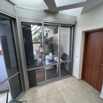 חלונות זכוכית עם תריסים פנימיים במרפסת