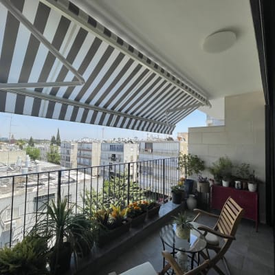 סוכך פסים שחור לבן על מרפסת עם צמחים