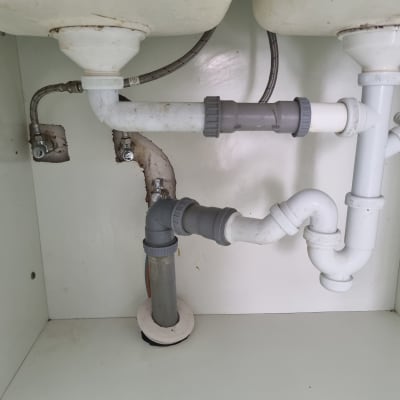 צנרת מתחת לכיור עם חיבורים ואביזרים