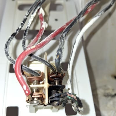 חוטי חשמל אדומים ושחורים מחוברים למתג