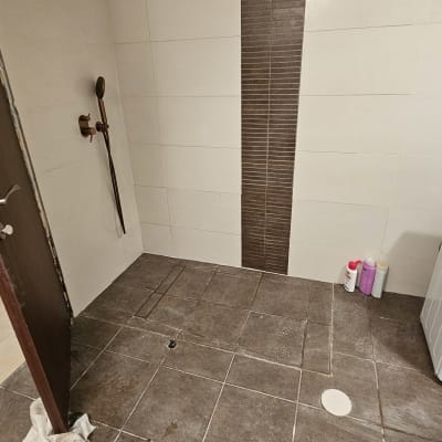 חדר רחצה עם אריחים חדשים ומקלחת מותקנת