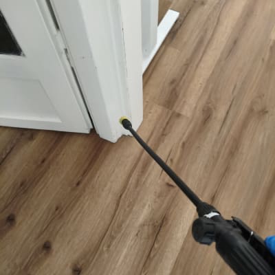 ריסוס מזיקים ליד דלת על רצפת עץ