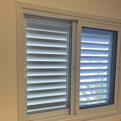 חלון אלומיניום עם תריסים פתוחים למחצה