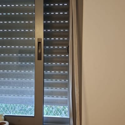 תריסים סגורים בחלון עם מסגרת מתכת