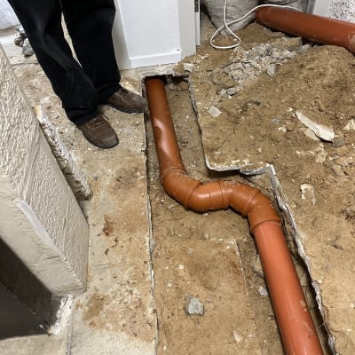 צינור כתום מונח בתעלה באדמה