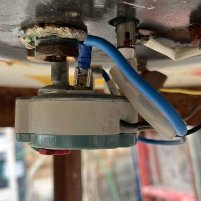 חוטים כחולים מחוברים לרכיב חשמלי מתכתי