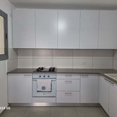 מטבח מודרני עם ארונות לבנים וכיריים גז