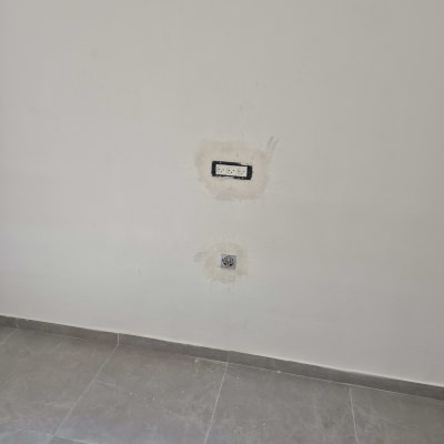 עבודת שפכטל והחלקת קיר מסביב לשקעי חשמל לפני צביעה