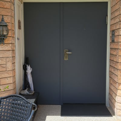 דלת מתכת כהה עם ידית זהב