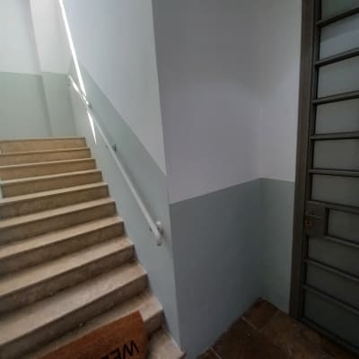 מדרגות עם שטיחון ברוך הבא ודלת בצד