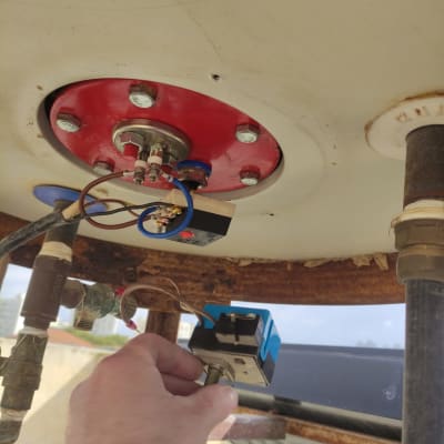 יד מחזיקה רכיב חשמלי מתחת לדוד שמש