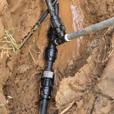 צינורות שחורים מחוברים באדמה רטובה