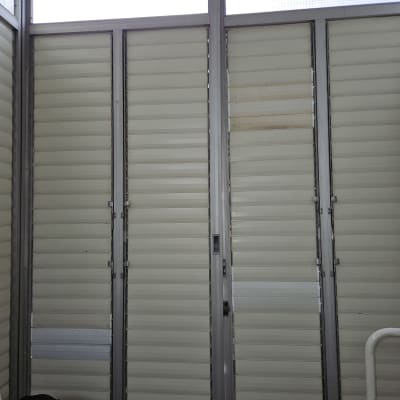 תריסים לבנים עם מסגרת מתכת אפורה