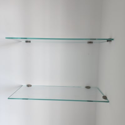 מדפי זכוכית מותקנים על קיר לבן