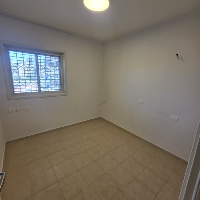 חדר ריק עם קירות צבועים ורצפת אריחים