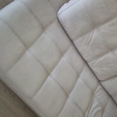 ספה בהירה על רצפת עץ, ללא אנשים או טקסט.