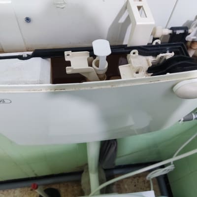 מיכל הדחה פתוח עם חלקים פנימיים נראים