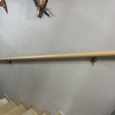 מעקה עץ מותקן על קיר מדרגות