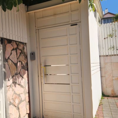 אינטרקום מותקן על קיר ליד שער לבן