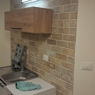 ארון מטבח עם כיור וקיר לבנים