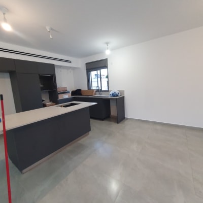 מטאטא אדום על רצפה נקייה במטבח ריק