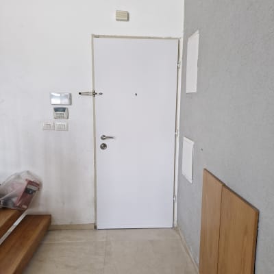 דלת לבנה עם מנעול, לוח מקשים ליד הדלת