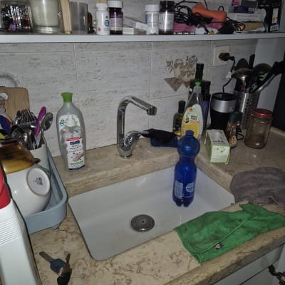 כיור מטבח עם ברז, כלים וחומרי ניקוי