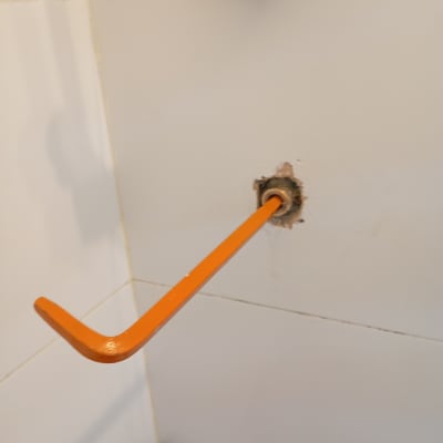 מפתח אלן כתום מחובר לקיר לבן