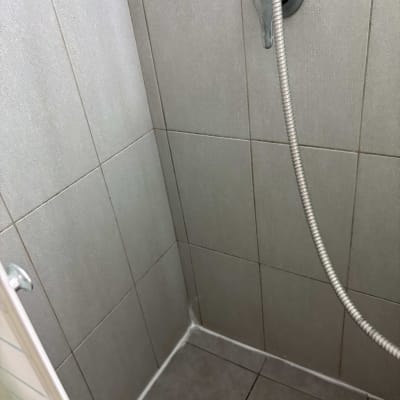 תא מקלחת עם אריחים וראש מקלחת