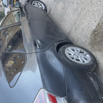 מכונית שחורה עם חלונות כהים וחישוקי גלגלים