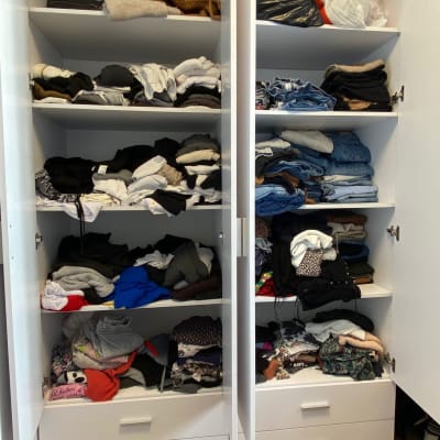 ארון בגדים עם מדפים מבולגנים מלאים בבגדים מקופלים