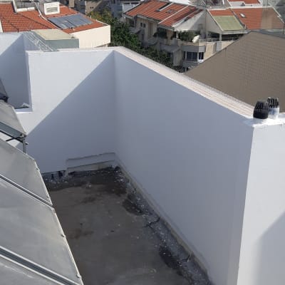 קירות לבנים צבועים על גג במהלך שיפוץ