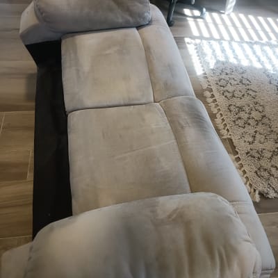 ספה אפורה בחדר עם שטיח וכיסא משרדי